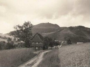 Waltersdorf. Ortsteilansicht mit Umgebindehaus. Blick zur Lausche (793 m)