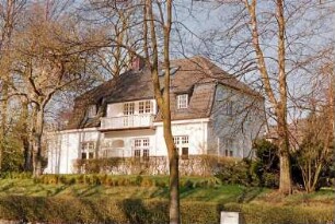Struhbarg 22: giebelständige Stadtvilla mit Krüppelmansarddach: Traufseite mit übereinander liegenden Freisitzen: rechts Straßenfront: links Anbau mit Altan an rückwärtiger Giebelseite: im Vordergrund Hecke an Straße Am Hünengrab