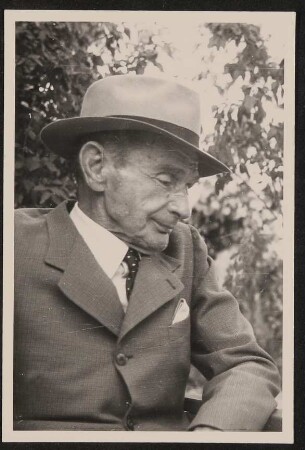 Portrait des alten Rudolf Kassner im Profil im Garten mit Hut