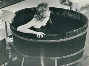 Hamburger Wasserwerke. Auch medizinische Bäder werden angeboten. Eine Frau nimmt ein Moorbad in einer Holzwanne. Aufgenommen für einen Badeprospekt