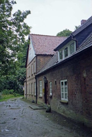 Dorfstraße 17: Bauernhaus: Traufseite mit Eingangstür: hinten Quergiebel mit Verbretterung