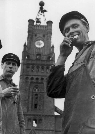 Hamburg. Hafen. Am Kaiserhöft vor dem Kehrwiederturm machen Hafenarbeiter ihr Frühstück. Sie lassen sich Brote schmecken. Im Hintergrund der Kehrwiederturm (Uhrenturm und Wasserstandanzeige am Kaispeicher A, auch Kaiserspeicher genannt am Kaiserhöft)