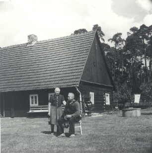 Ehepaar mit Dudelsack : Volksmusik - Interpreten und Instrumente. Ort: Trjebin/ Trebendorf. Dudelsackspieler Hanzo Schuster mit Ehefrau vor seinem Wohnhaus aus Holz, 1980