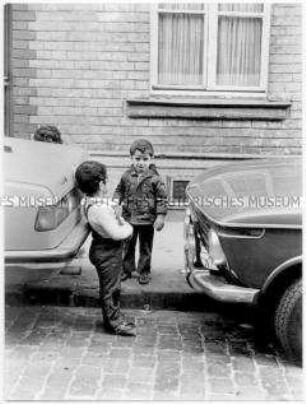 Kinder zwischen parkenden Autos (Altersgruppe bis 14)