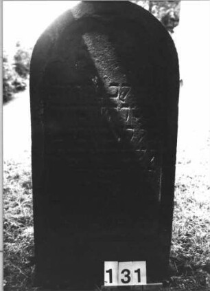 Grabstein 131 (Index: 100085484) Maße HxBxT: 107x54x15 cm Beschreibung: Stele, Rundbogenabschluß, Schriftfeld eingetieft mit Maßwerk auf Vorderseite: Grabstein 131