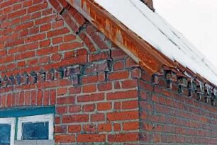 Backsteinkate: Giebelseite Wohntrakt: Detailaufnahme: Hausecke an Dachkante und Traufe, Backsteinzier