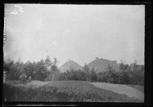Reichsburg Trifels bei Annweiler am Trifels (Rheinland-Pfalz): 2 Bergkegel mit den Bergfrieden von Burgruinen hinter einem Obstgarten