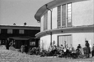 Bergstation: Sonnende Leute im Schnee