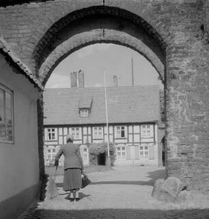 Stralsund. Blick durch einen Tordurchgang auf eine Straße mit Fachwerkhäusern