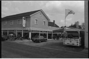 Autohaus Riegel: Vorburgstraße: Neueröffnung der Ausstellungs- und Geschäftsräume: Außenansicht: Schaufenster, Firmenschild: davor Autos, Besucher, Bus mit Fahne und Luftballons