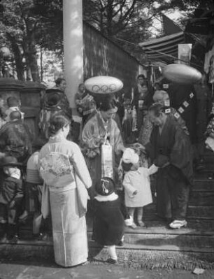 Kashima-Schrein, wahrscheinlich in Shinagawa, während des Shichi-go-san-Festes im November : Kashima-Schrein, wahrscheinlich in Shinagawa, während des Shichi-go-san-Festes im November. Besucher in traditioneller japanischer wie europäischer Festkleidung
