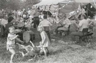 Volksfest I : Colditz. Park. Ausschnitt von einem Volksfest. Im Vordergrund toben Kinder. Im Hintergrund sieht man eine Musikkapelle die vor einem Zelt musiziert