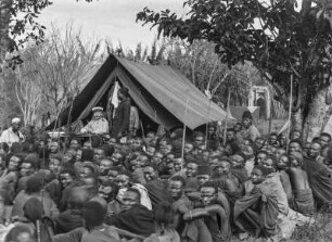 Versammlung mit Hauptmann Kurt Johannes : Versammlung mit Männern der Chagga und Hauptmann Kurt Johannes, der vor einem Zelt an einem Tisch sitzt