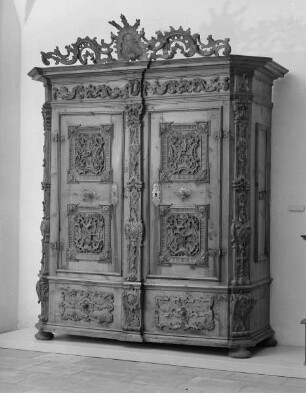 Schrank mit Reliefschnitzerei und Aufsatz