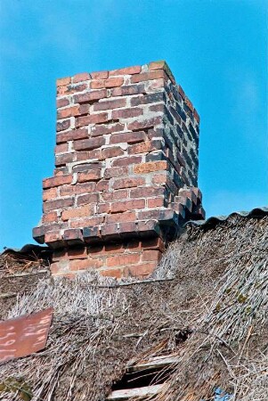 Düpenau (5): Haus mit Reetdach: Detailaufnahme: Schornstein, Schadstellen in Reetdeckung, Schild