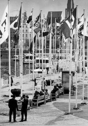 Hamburg-Neustadt. Besucher sitzen auf Bänken des Bootsanlegers am Jungfernstieg. Flaggen wehen. Aufgenommen 1964