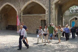 London - Touristen im Tower : Touristengruppe betritt den Innenbereich des Tower vom unteren Mauerring, aufgenommen in London im Mai 2006