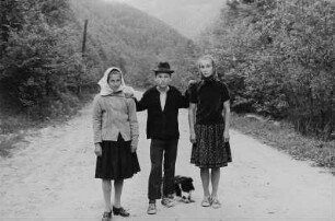 Zwei Mädchen und ein Junge mit Hund auf einer Straße (im Kreis Maramures ?)