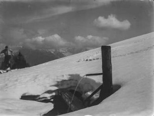 Brunnen : Brunnen inmitten eines Schneefeldes, links ein Skifahrer