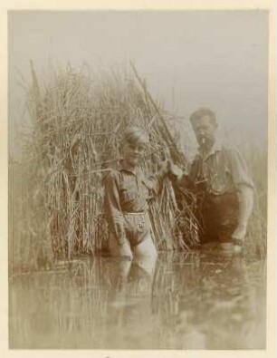 Königswartha, Rudolf Zimmermann mit einem Jungen an einem Fotoversteck aus Schilf in einem Teich stehend