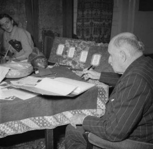 Marburg. Der Maler Prof. Ernst Vollbehr (1876-1960) in seinem Atelier am Tisch sitzend