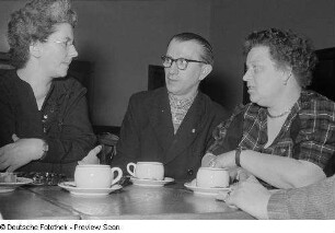 Zwei Frauen und ein Mann beim Kaffeetrinken