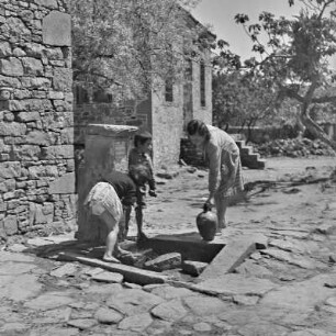 Griechenland. Insel Limnos. Zentraler Brunnen. Wasserkrüge werden gefüllt.