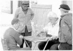 Ältere Männer sitzen vor einem Haus und spielen Backgammon (Prämiertes Foto Sonderthema: Spiele spielen)