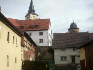 Ansicht von Süden aus dem Ort mit Kirche über Kirchhof in erhöhter Lage über dem Ort - südwestlich des Kirchturms der runde Wehrturm am Aufgang vom Ortsweg