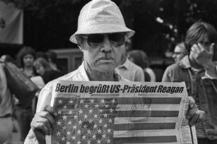 Anti-Reagan-Demo, Berlin, Nollendorfer Platz, 10.-11.06.1982, Schlacht am Nolli. Hier: ein Pro-Reagan Demonstrant mit Zeitung: Berlin begrüßt US-Präsident Reagan