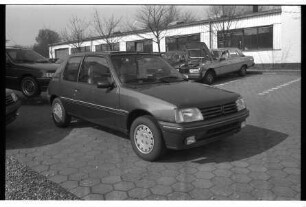 Autohaus Helmut Steinke: Gänseberg: Peugeot-Vertragshändler: Parkplatz: Peugeot 205 Sondermodell Roland Garros, hinter Windschutzscheibe Preisschild: dahinter Pkw aufgebockt, hinten Autos, Flachbau: 1. April 1990