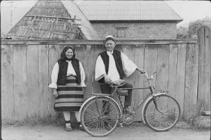 Altes Paar in Tracht (aus dem Bezirk Maramures) mit einem Fahrrad
