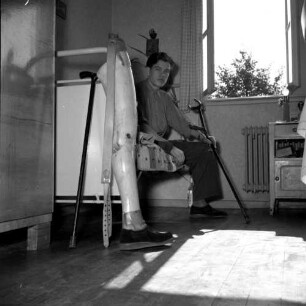 Hessisch-Lichtenau, Am Mühlenberg. Orthopädische Klinik. Patientenzimmer. Beinamputierter Patient auf dem Bett sitzend, daneben Beinprothese