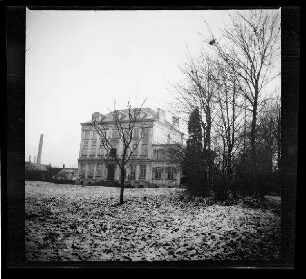 Phalempin (Dep. Nord, Frankreich): Villa ("Kanzlei des Generalkommandos in Phalempin") in einer Parkanlage, im Hintergrund ein Fabrikschornstein, im Vordergrund eine verschneite Wiese neben einem Parkweg (Vorderansicht, Distanzaufnahme)