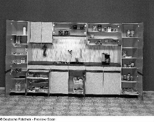 Anbauküche : Leipzig. Leipziger Herbstmesse, 1983. Anbauküche. Holz, folienbeschichtet mit Wolkendekor (1983; VEB Möbelwerk Weißensee). Ansicht mit geöffneten Türen und Schüben
