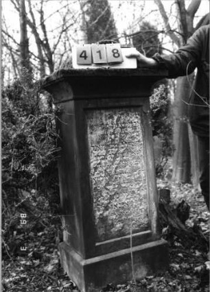 Grabstein 418 (Index: 99752687) Material: Sandstein Zustand: abgeblättert mit Textverlust Maße HxBxT: 147x50x35 cm Beschreibung: Stele, Sockel, Abdeckplatte mit Aufsatz, rechteckiges Schriftfeld eingetieft: Grabstein 418