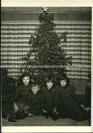Vier Mädchen unter dem Weihnachtsbaum