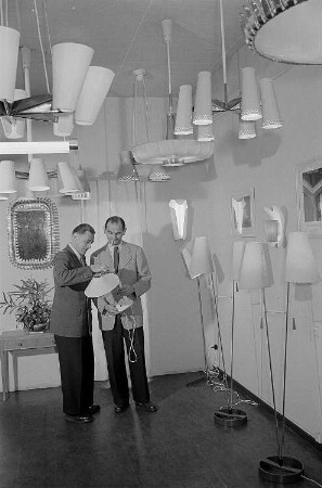 Zwei Männer begutachten eine auf der Leipziger Herbstmesse 1955 ausgestellte Tischlampe