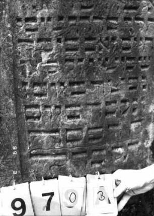 Grabstein 970 (Index: 99751399) Material: Sandstein Zustand: leicht verwittert Maße HxBxT: 105x62x13 cm Beschreibung: ädikulaart. Stele mit Pilastern, eingezog. Segmentbogenabschl. , Schrift eingetieft: Grabstein 970B