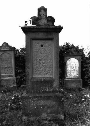 Grabstein 51 (Index: 99891681) Material: Sandstein Zustand: Inschrifttafel zerstört Maße HxBxT: 170x60x28 cm Beschreibung: rechteckige Stele auf Sockel aufgesetzter Mittelakroter Symbolik: Blüte im Mittelakroter: Grabstein 51