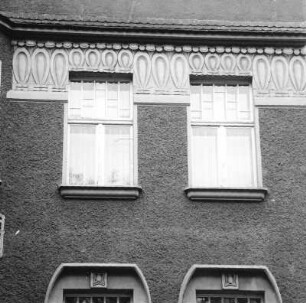 Cottbus-Mitte, Wernerstraße 9. Wohnhaus mit Laden (um 1908). Fensterpaar und Gesimsfries (2. Obergeschoß)