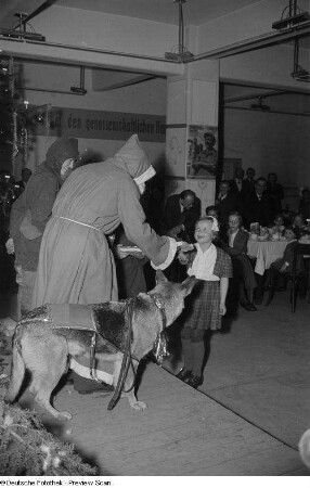 Weihnachtsmann, einem Mädchen ein Geschenk überreichend