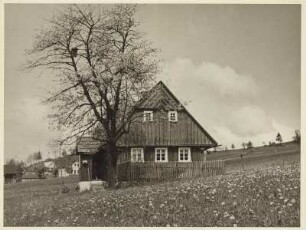 Frühling im Sudetenland. Hölzernes Bauernhaus am Rand von Falkenau an der Eger (Sokolov).