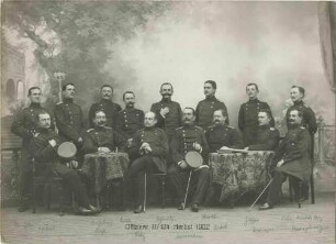 Offiziere (fünfzehn Personen) des II. Bataillons des Regiments sitzend und stehend in Fotoatelier vor Kulisse