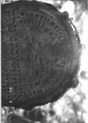 Grabstein 197 (Index: 99800026) Material: Sandstein Zustand: verwittert Maße HxBxT: 89x57x12 cm Beschreibung: Stele, Rundbogenabschluß, Schriftfeld eingetieft Symbolik: Rosette: Grabstein 197 (Detailaufnahme 1)