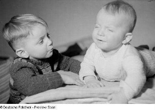 Porträt eines kleinen Jungen und eines sich aufstützenden Säuglings