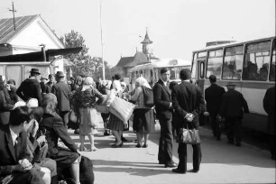 Suceava: Menschenansammlung an Bushaltestelle, Hintergrund Kirche