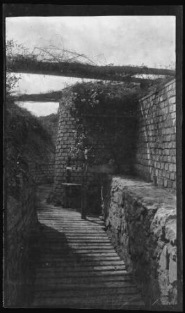 "Maasbogen-Stellung" (bei Saint-Mihiel (Dep. Meuse, Frankreich)): Sitzgelegenheit mit Tisch im gemauerten Schützengraben ("Sommerlaube") (Distanzaufnahme)