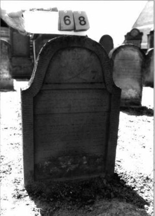 Grabstein 68 (Index: 99798192) Material: Sandstein, rot Zustand: leicht verwittert Maße HxBxT: 91x60x11 cm Beschreibung: Stele, geschweifter Abschluß Symbolik: gekreuzte Palmzweige: Grabstein 68