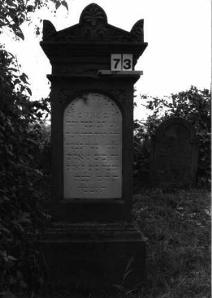 Grabstein 73 (Index: 99891725) Material: Sandstein, Inschrifttafel weißer Marmor Zustand: sehr gut Maße HxBxT: 163x54x31 cm Beschreibung: rechteckige Stele auf Sockel, großer Stirnziegel: Mittelakroter und Eckakrotere Symbolik: Palmette im Mittelakroter, in Giebel Blattwerk: Grabstein 73